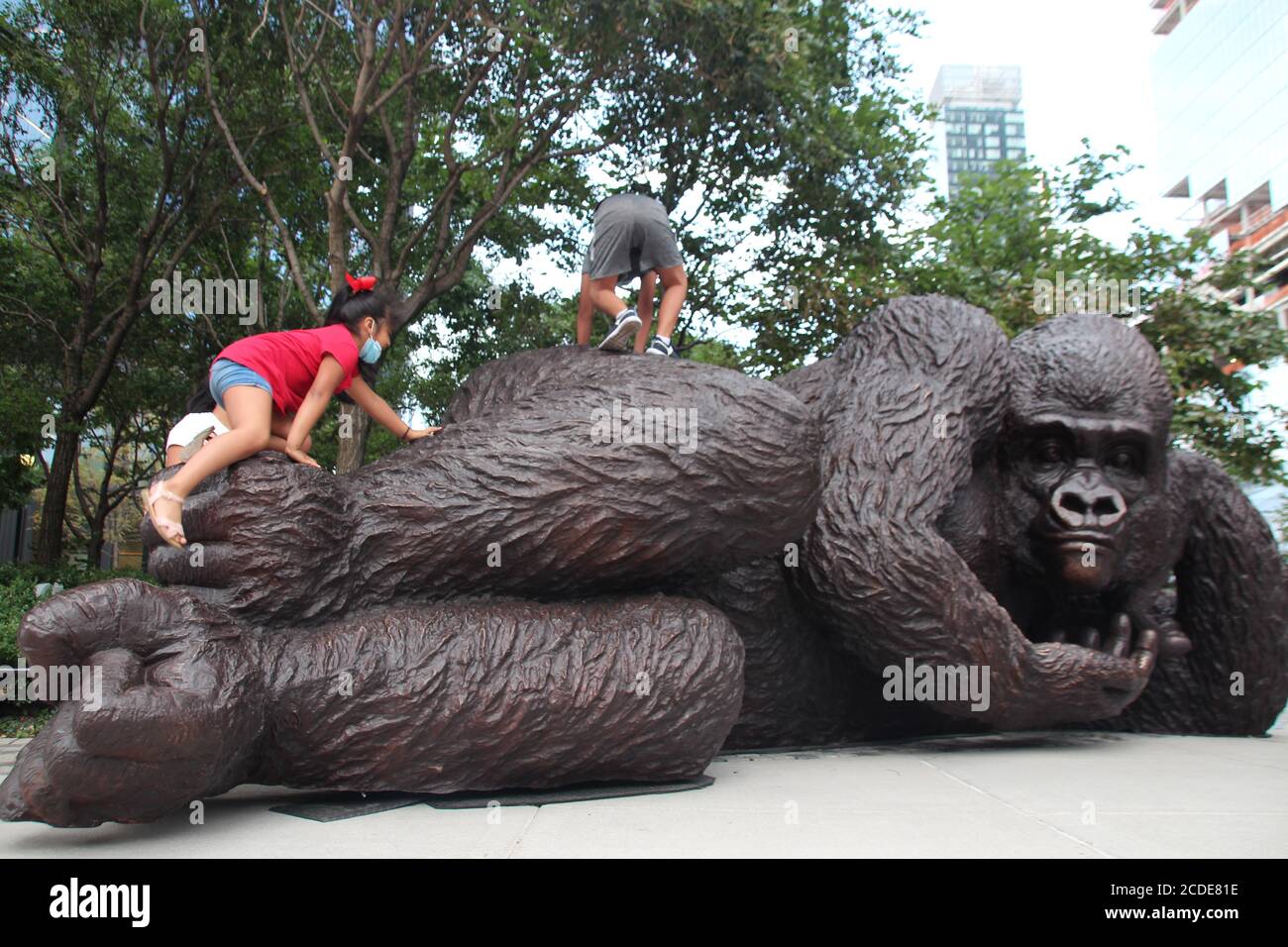 New York, USA. 26th Aug, 2020. Kids climbing on a gorilla statue. An