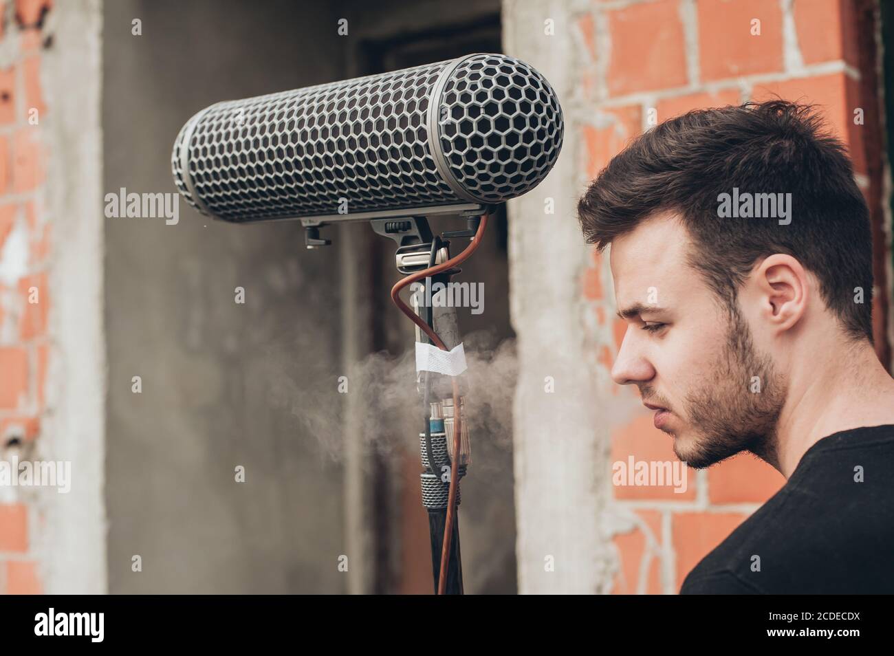 Behind the scene. Sound boom operator resting on the set and hold