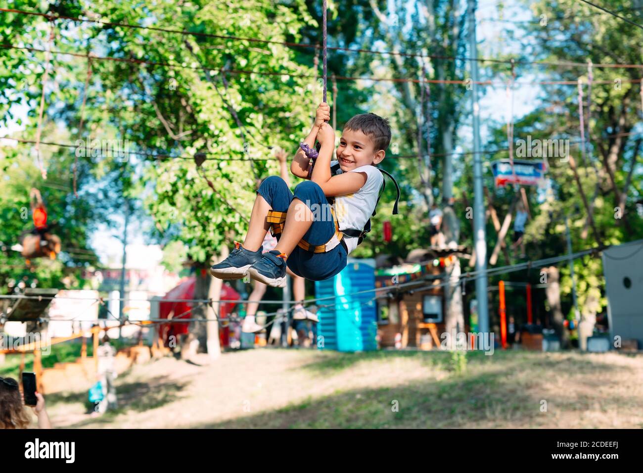 Happy kid enjoying activity in a climbing adventure park. Stock Photo