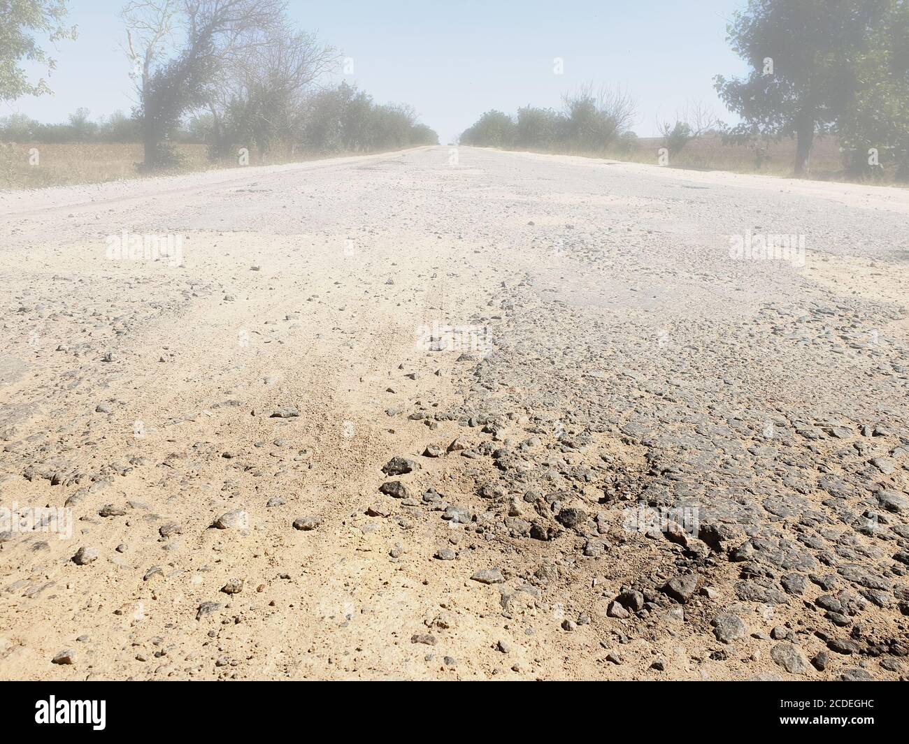 Dangerous road, potholes in the asphalt on the road and fog Stock Photo