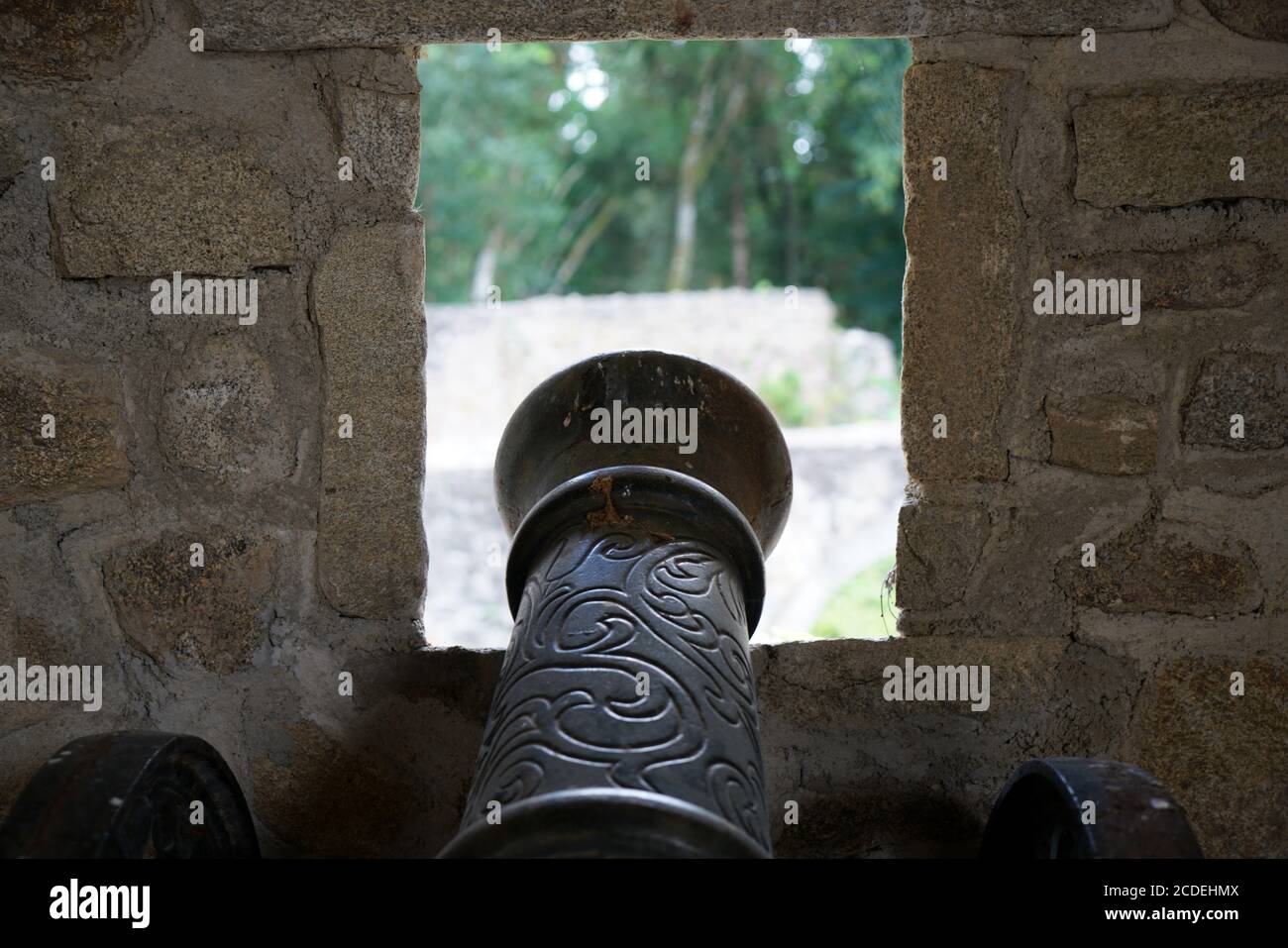 Old iron cannon leaned on the window in the fortress Stock Photo