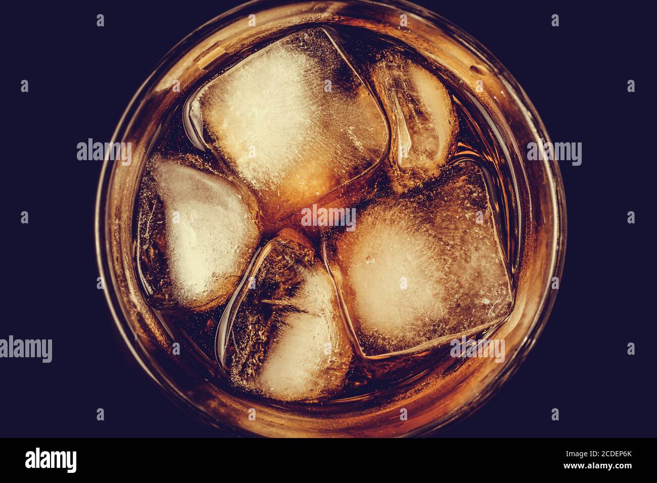 A glass of cola with ice close-up in the dark. Brown carbonated drink, non-alcoholic beverage with caffeine. Top view Stock Photo