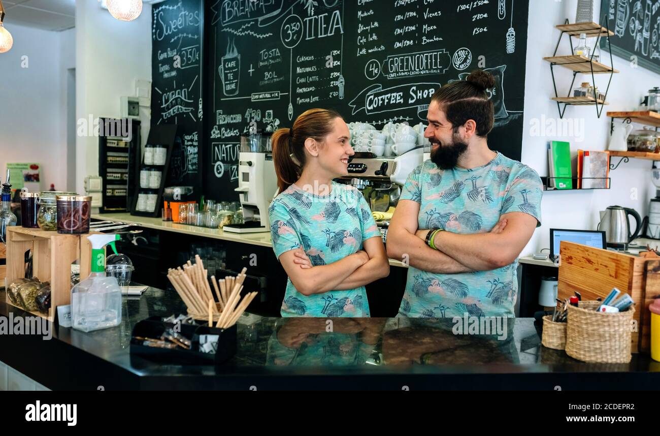 Couple of coffee shop owners posing smiling Stock Photo