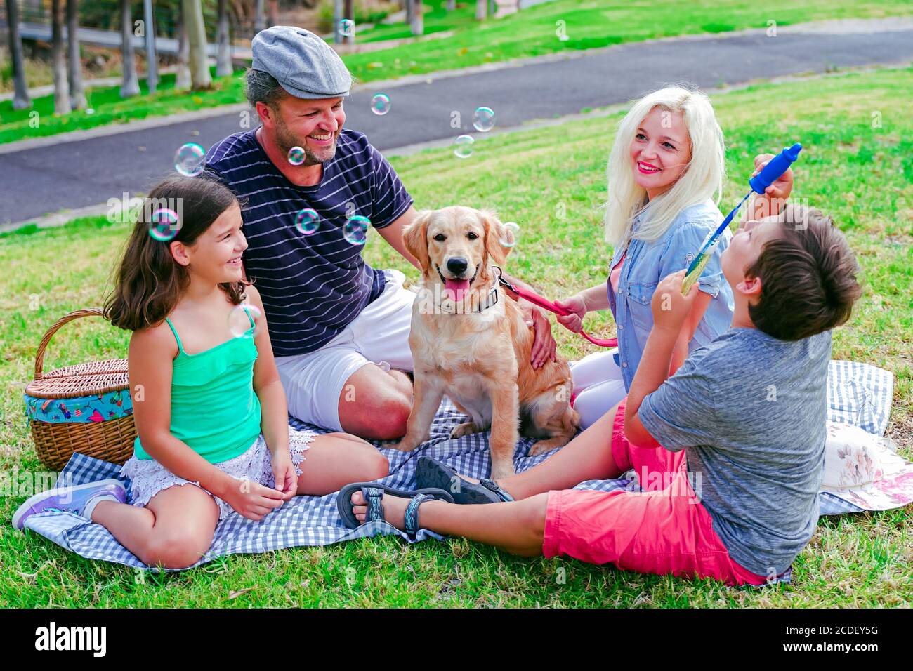Happy family with their dog in a good sun day. The boy playing with ...