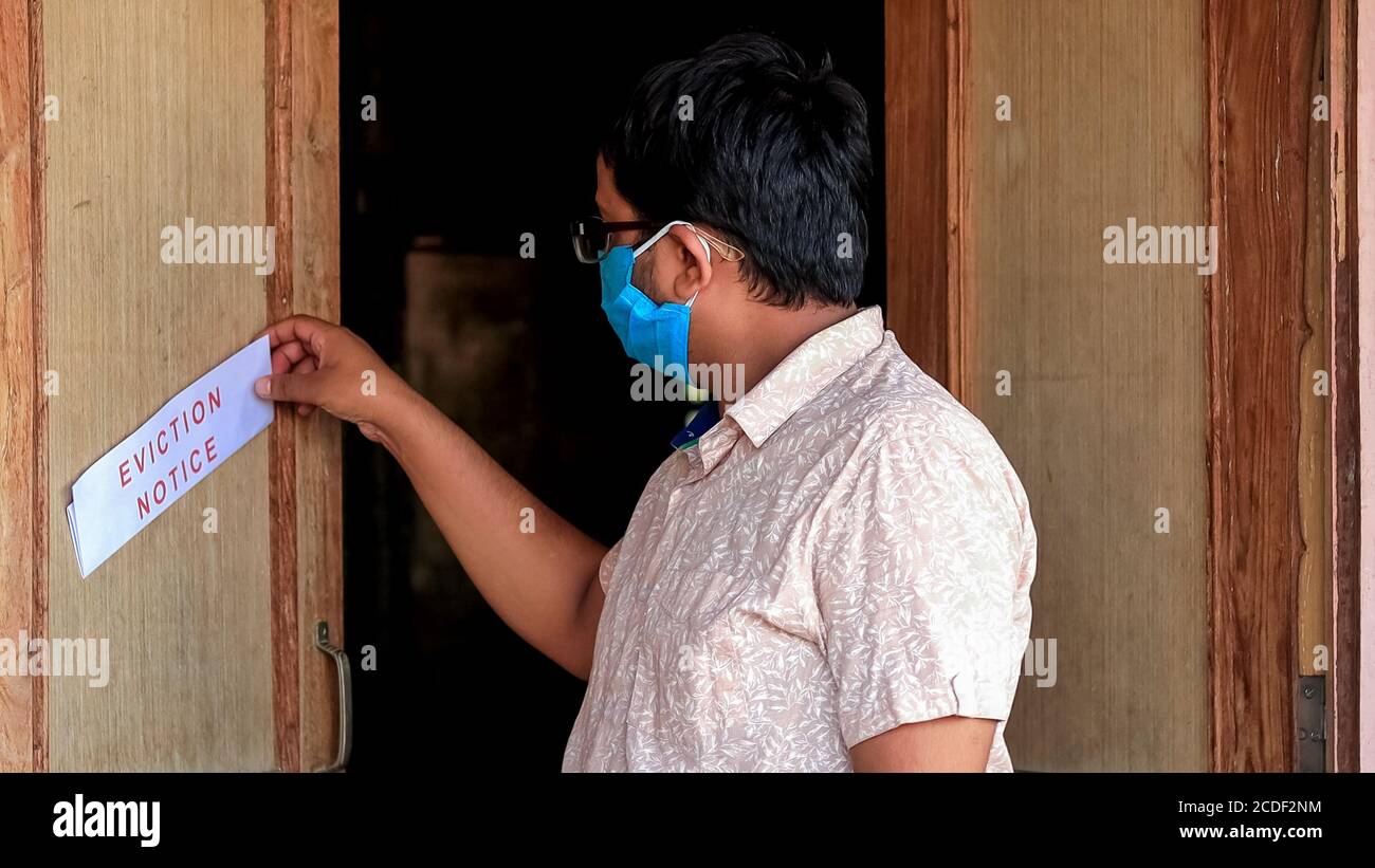 Asian man finds eviction notice on the door of the house Stock Photo