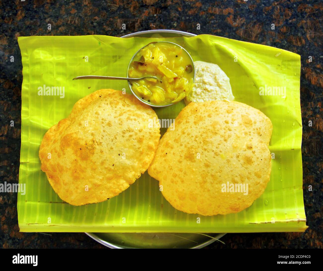 Traditional Indian food - two fried cake (puri) with vegetable curry and coconut chatni on banana leaf in restaurant of Madurai, Tamil Nadu,  India Stock Photo