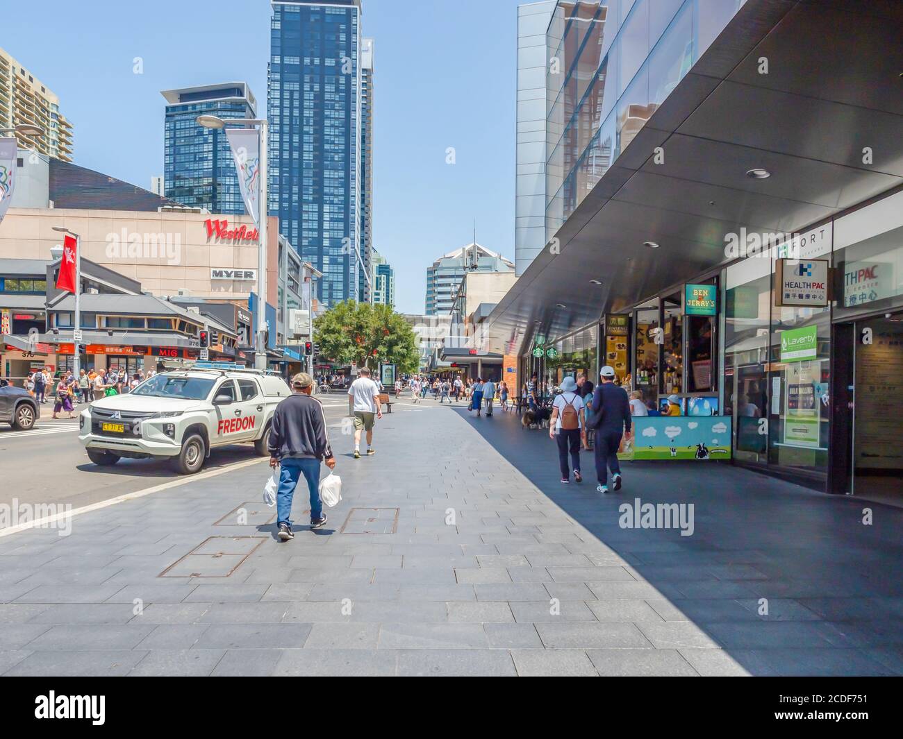 Sidewalk in a busy are in Chatswood Suburb in Lower North Shore and Pedestrians walking along the pavement on a sunny summer afternoon Stock Photo
