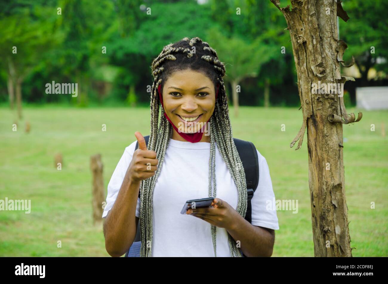 Young African female student giving a thumbs up and smiling Stock Photo ...