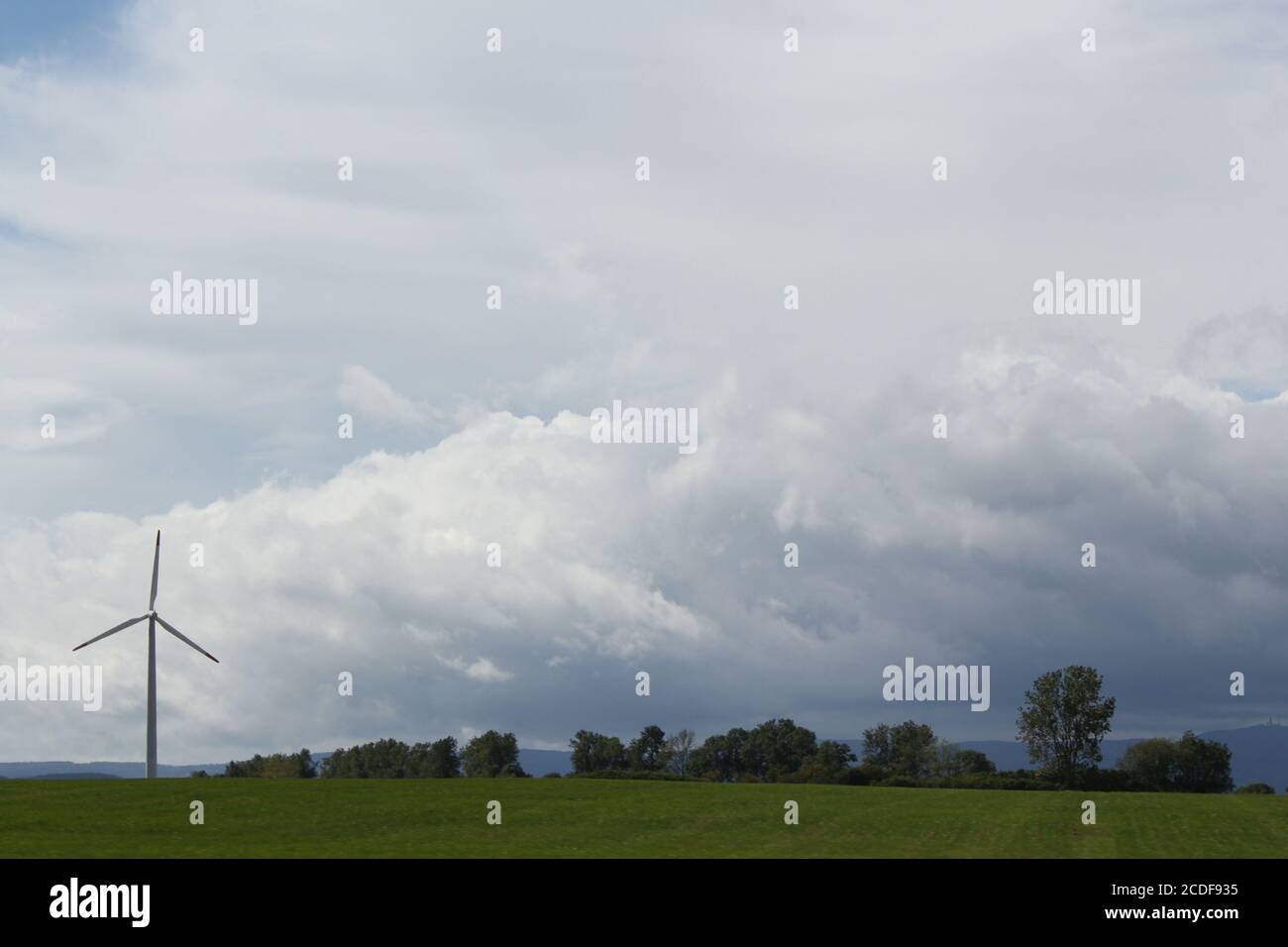 wind turbines farm on a field with cloudy sky Stock Photo - Alamy