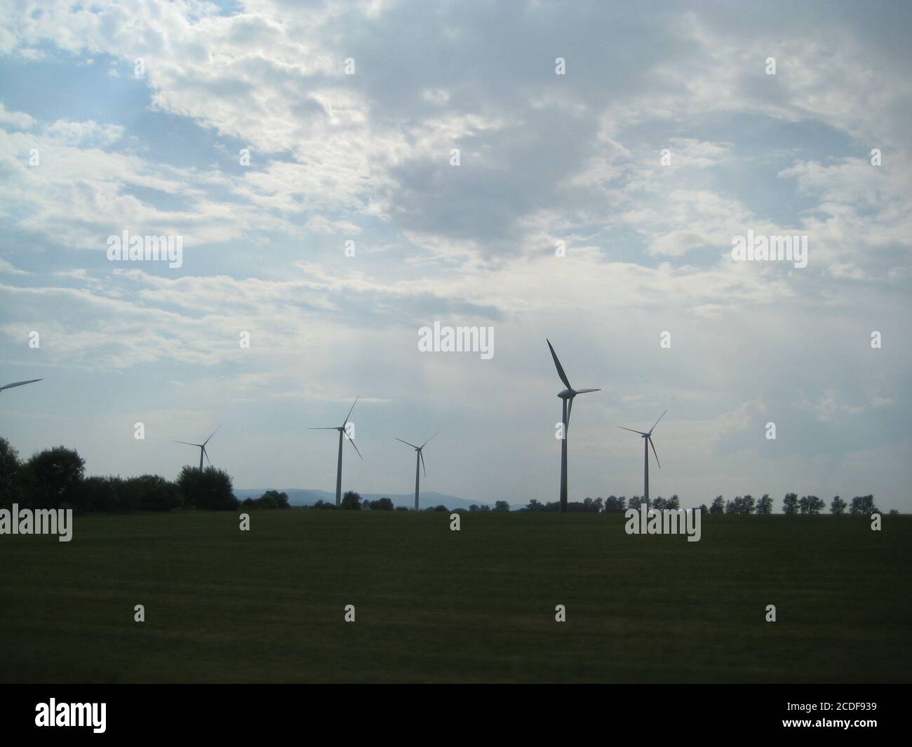 wind turbines farm on a field with cloudy sky Stock Photo - Alamy
