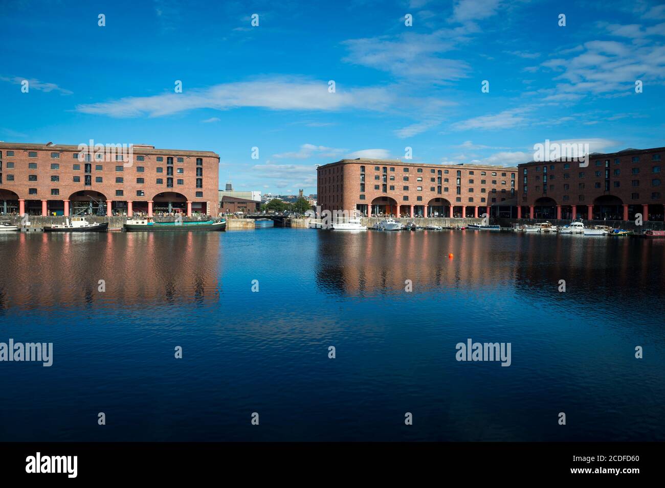 View across calm water in a harbour to the Albert Dock buildings in Liverpool Stock Photo