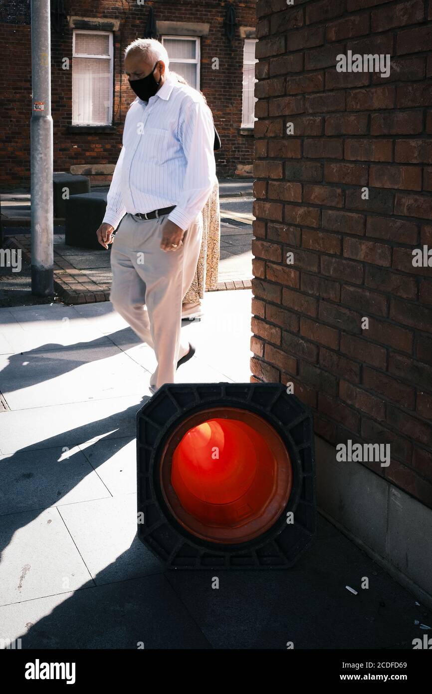 An Asian man wearing a face mask to protect against Covid 19 pictured in Preston City Centre, UK. Stock Photo