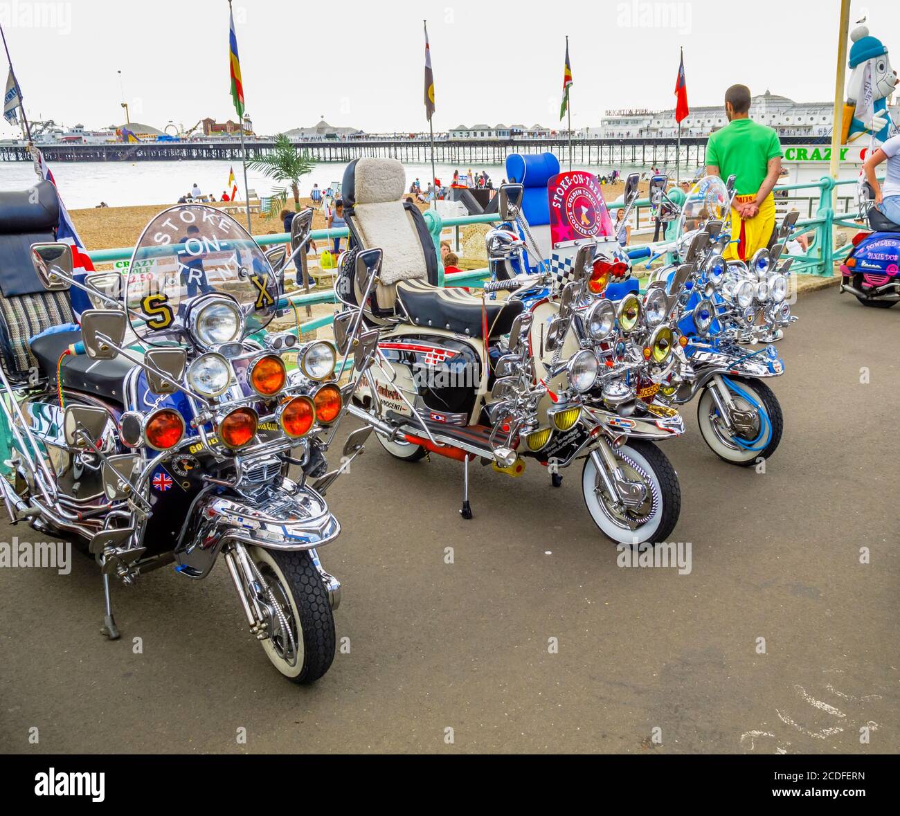 Vintage motor scooter motorbikes with headlamps in Brighton from the Mods and Rockers era, with multiple headlights and wing mirrors Stock Photo