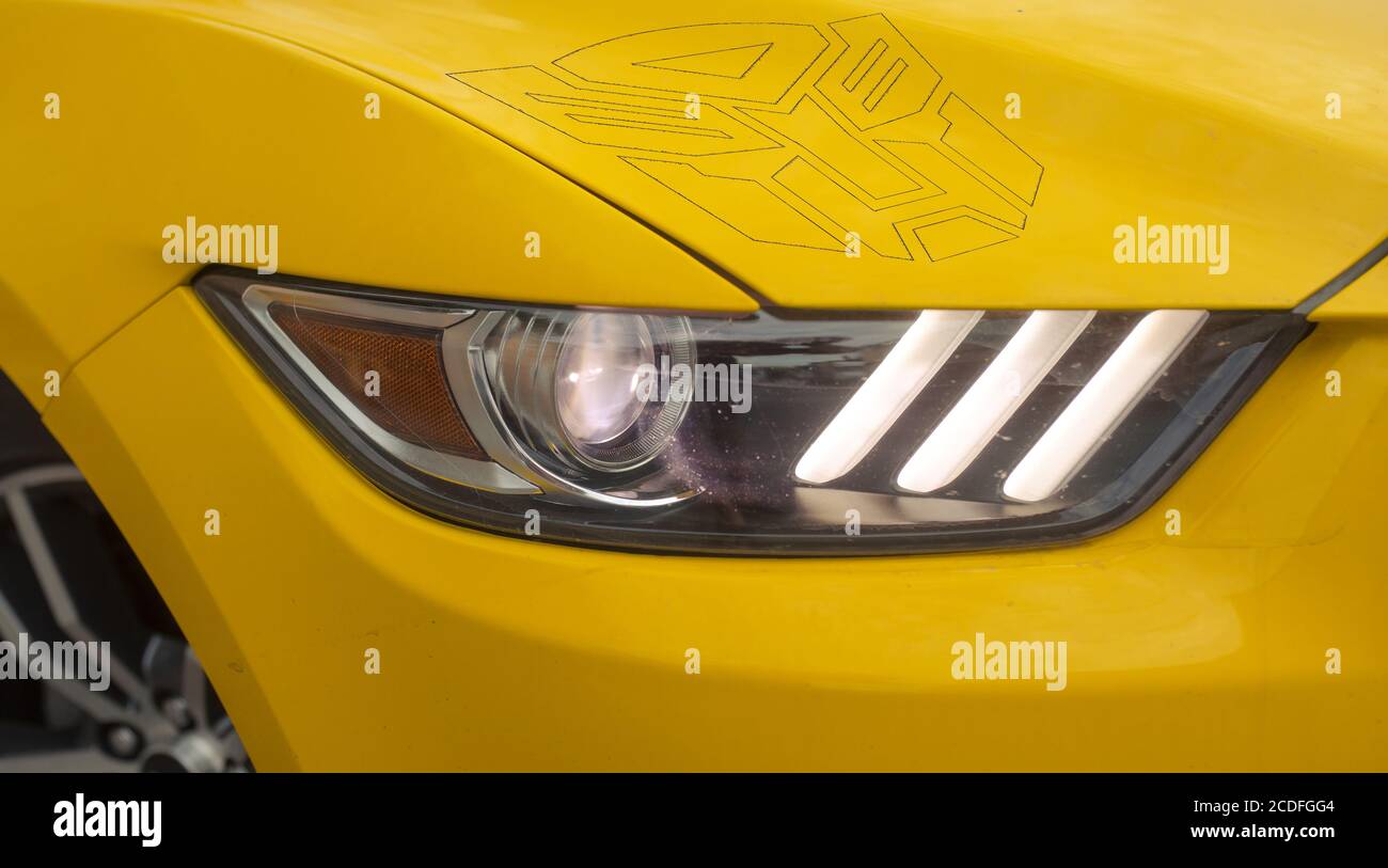 Front of a yellow car with the autobot logo closeup. Yellow car or robot transformer. Stock Photo