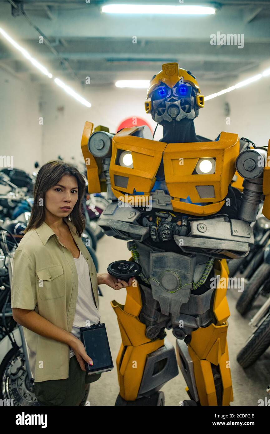 Robot transformer stands in garage near girl Stock Photo Alamy