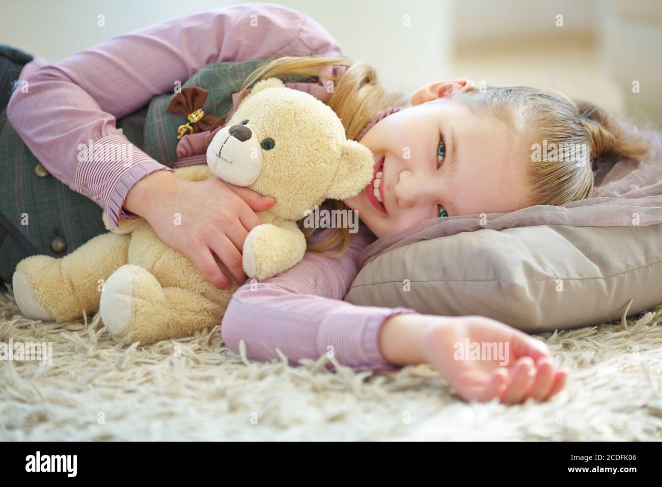 Girl cuddles with a teddy bear in her arms Stock Photo - Alamy