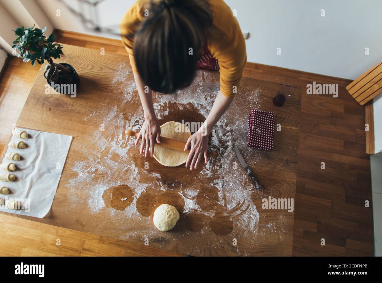 High angle view of woman kneading bread dough on kitchen table Stock Photo