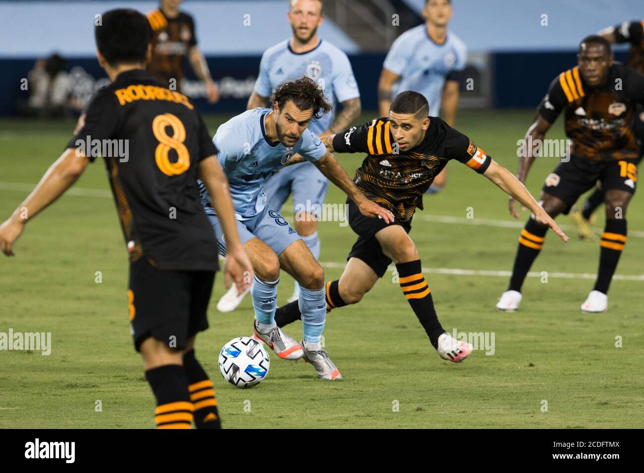 Kansas City, Kansas, USA. 25th Aug, 2020. At central action for ball possession are Sporting KC midfielder Graham Zusi #8 (l) and Houston Dynamo midfielder Matias Vera #22 (r) during the first half of the game. Credit: Serena S.Y. Hsu/ZUMA Wire/Alamy Live News Stock Photo