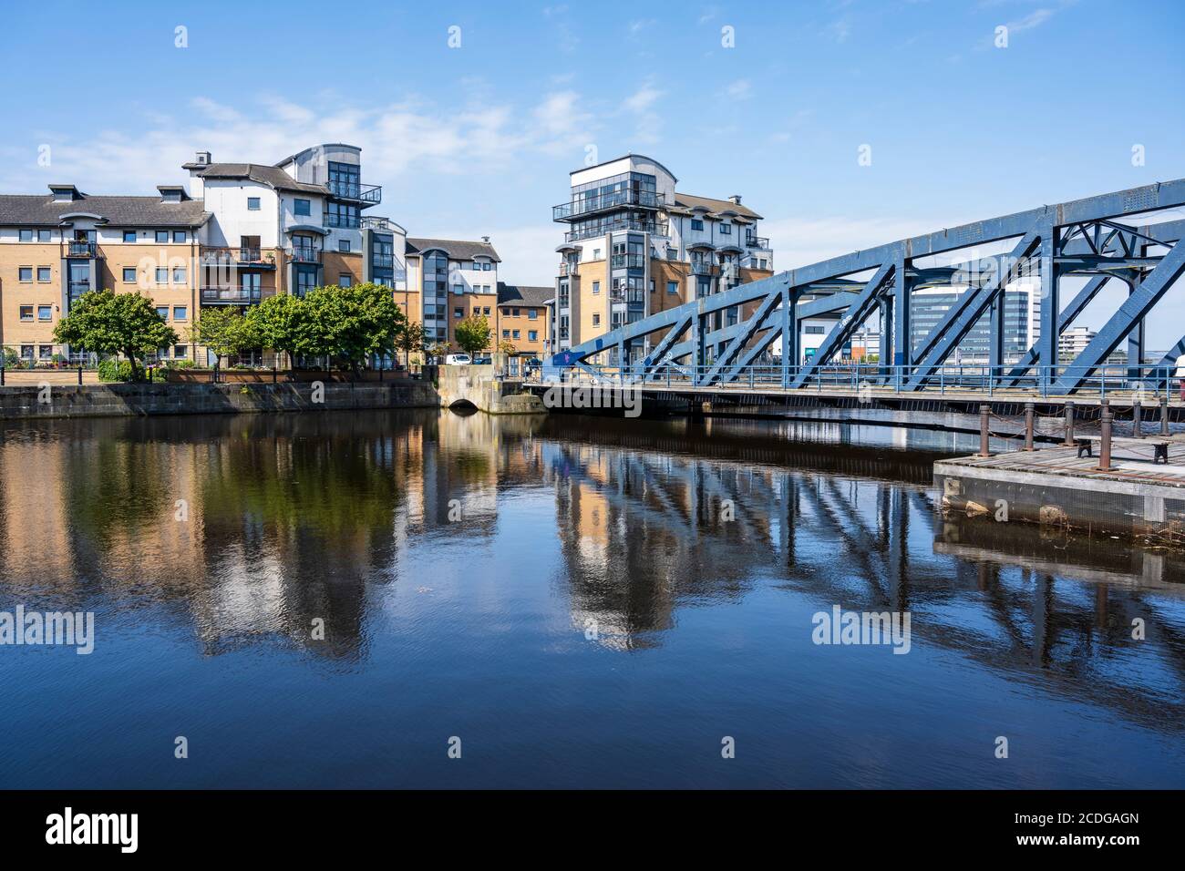 Modern apartment blocks on Rennie’s Isle and Victoria Swing Bridge reflected in the Water of Leith in Leith, Edinburgh, Scotland, United Kingdom Stock Photo