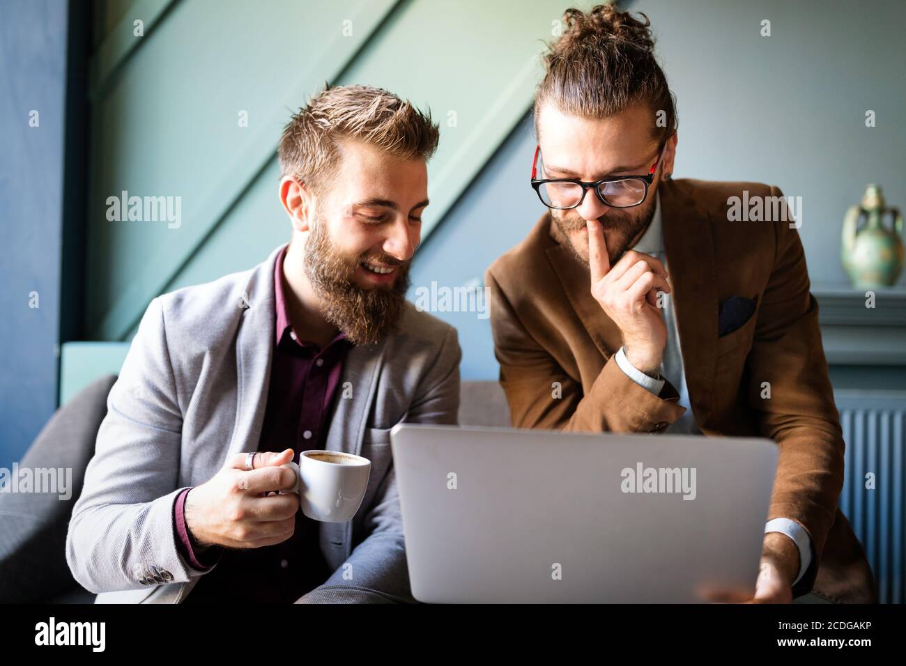 Sharing fresh ideas. Group of young business people in smart casual wear talking and smiling Stock Photo