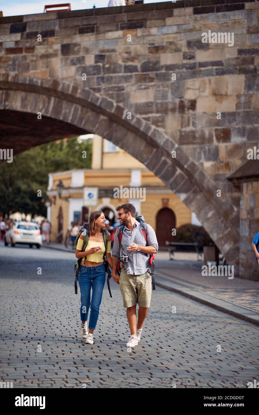 Young man and woman in love walking in the streets of Prague. Travel, tourism and people concept. Stock Photo