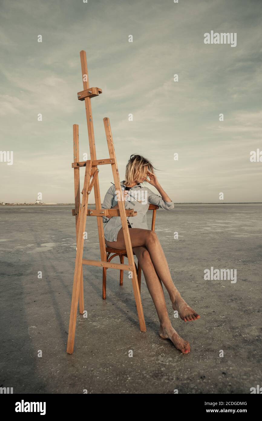 Young artist girl thinks of a summer landscape near a salt lake. Empty space to copy the inscriptions Stock Photo