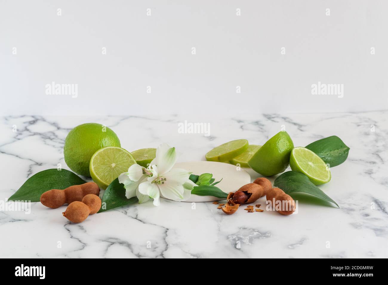 A staged mock up with sweet tamarind, green lemon and some blooms for cosmetics advertising Stock Photo