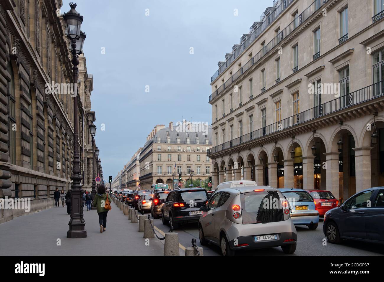 People and cars on Rivoli street at the Louvre museum building near the