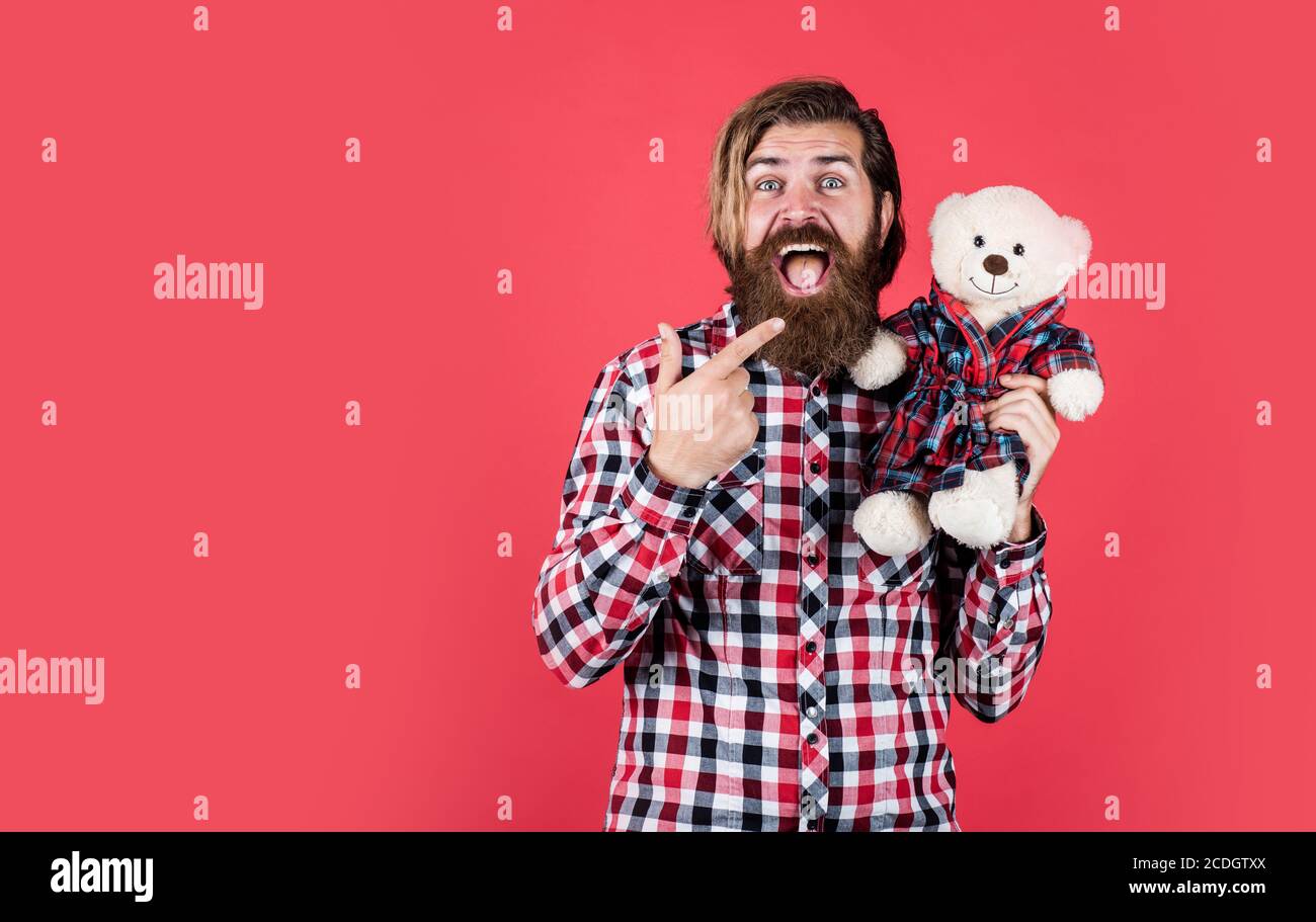 look at that. Childish mood concept. guy enjoy valentines day. best present ever. Valentines day gift for beloved. Holiday celebration concept. Guy with happy face plays with soft toy. Stock Photo