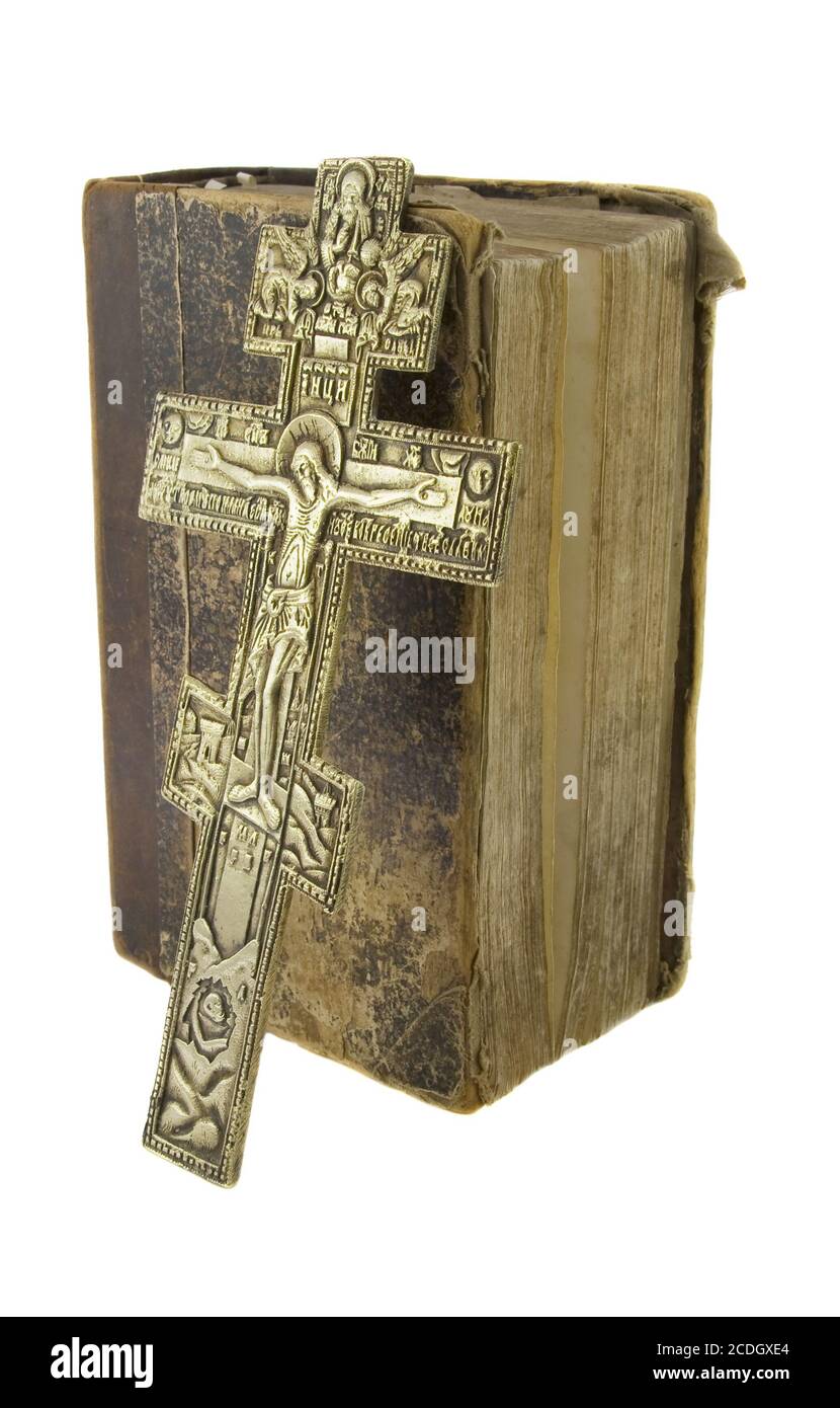Very old vintage bible and big church cross near to it isolated over white background Stock Photo