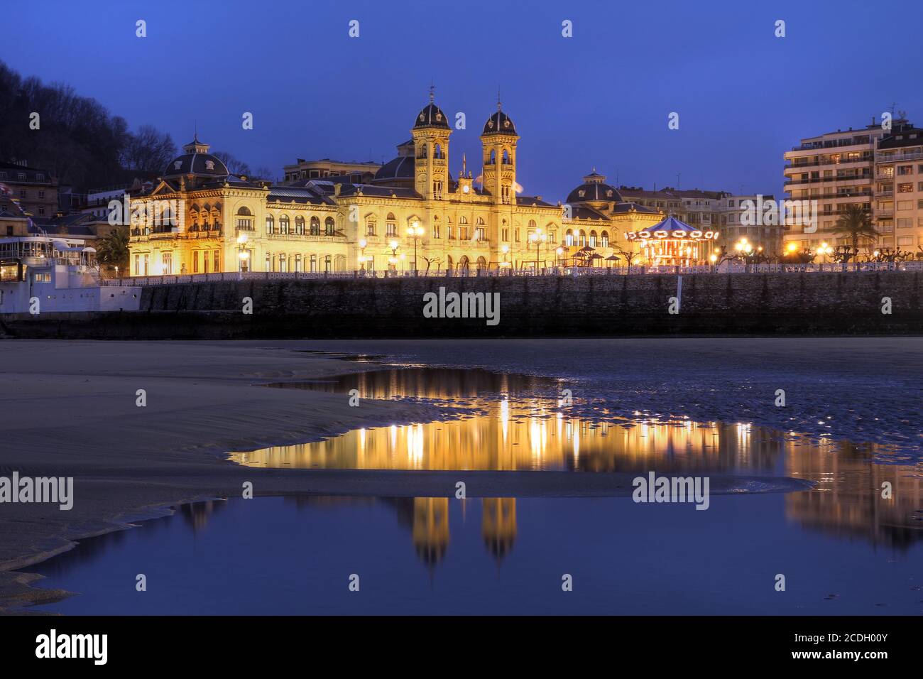 Night scene witht the City Hall of San Sebastian (Donostia in Basque country language) in Spain taken from the city's famous beaches. The retreat of t Stock Photo
