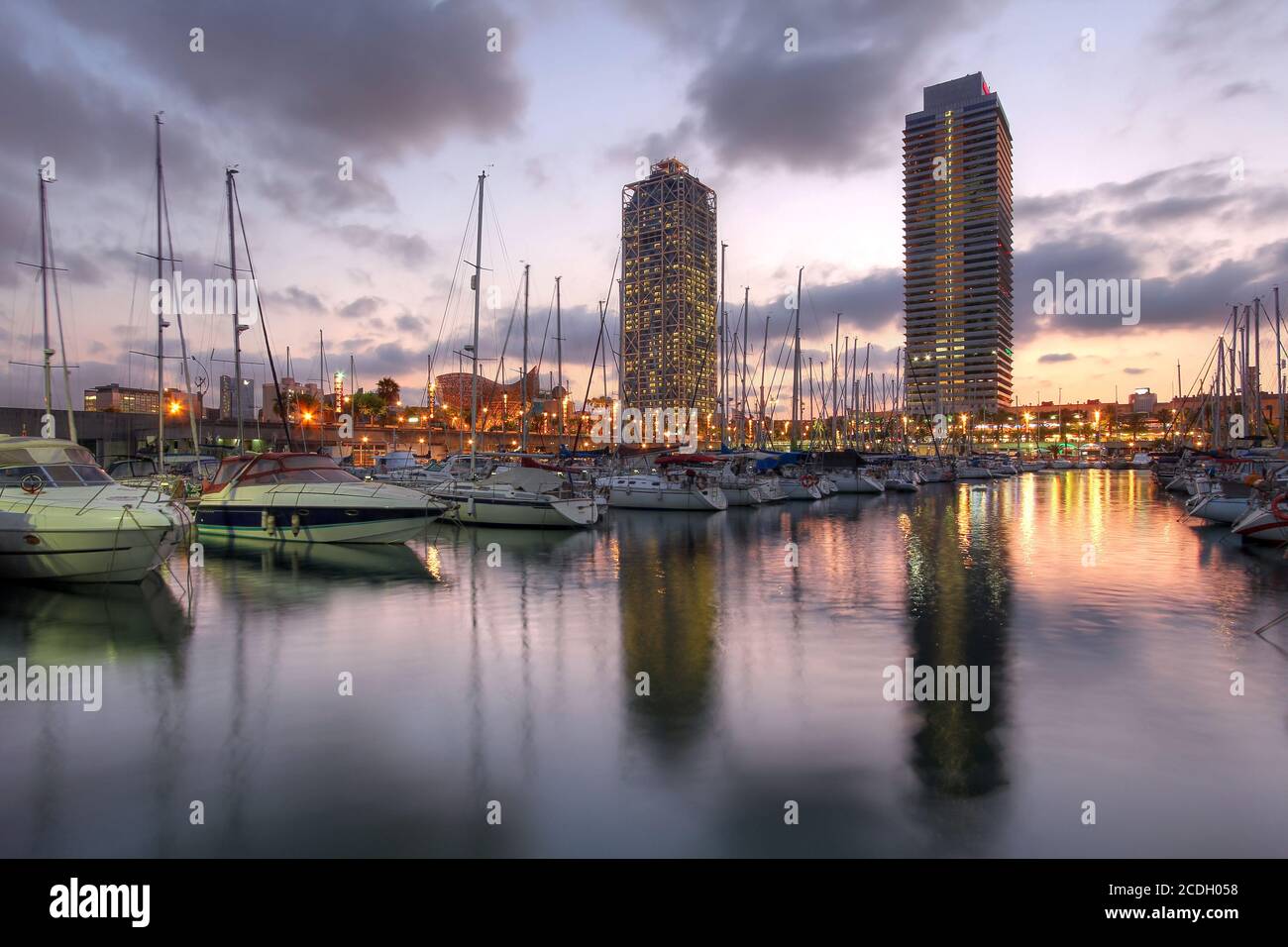 Twin skyscrapers towering over the marina in Port Olimpic (Olympic Harbor), Barcelona, Spain at sunset. Stock Photo