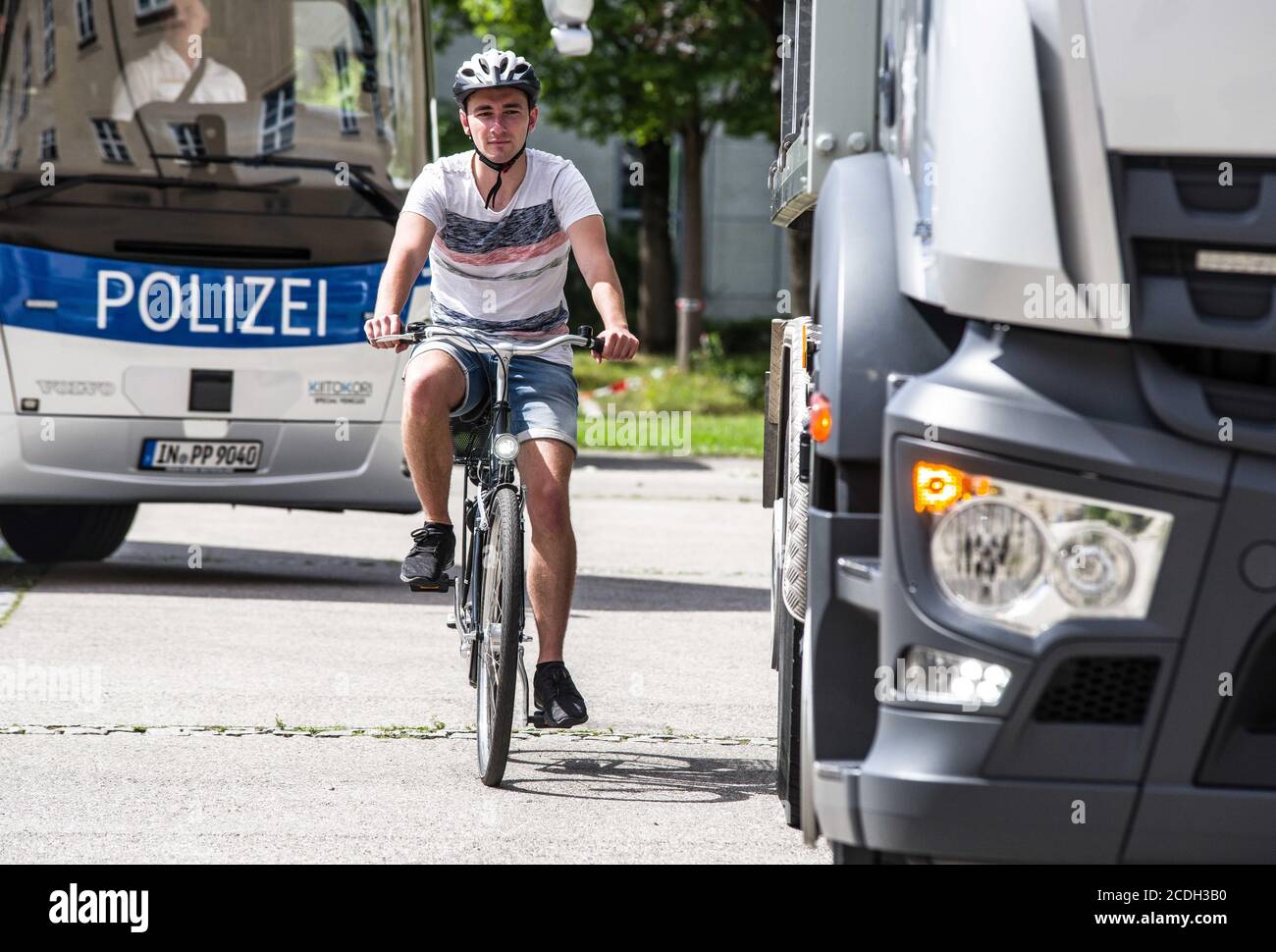 Munich, Bavaria, Germany. 28th Aug, 2020. A member of the Munich Bereitschaftspolizei rides a bicycle to trigger the turning assistant systems. Bavarian Interior Minister Joachim Herrmann alongside the Bavarian Police revealed service vehicles outfitted with the new turning assistant (Abbiegassistent) devices. In 2018 alone 455 bicyclists were killed, with trucks turning blind as one preventable cause. The turning assistant systems are currently voluntary, but in 2022 will become mandatory for old and new trucks and in 2024 for all vehicles as part of an EU-wide safety program. (Credit Ima Stock Photo