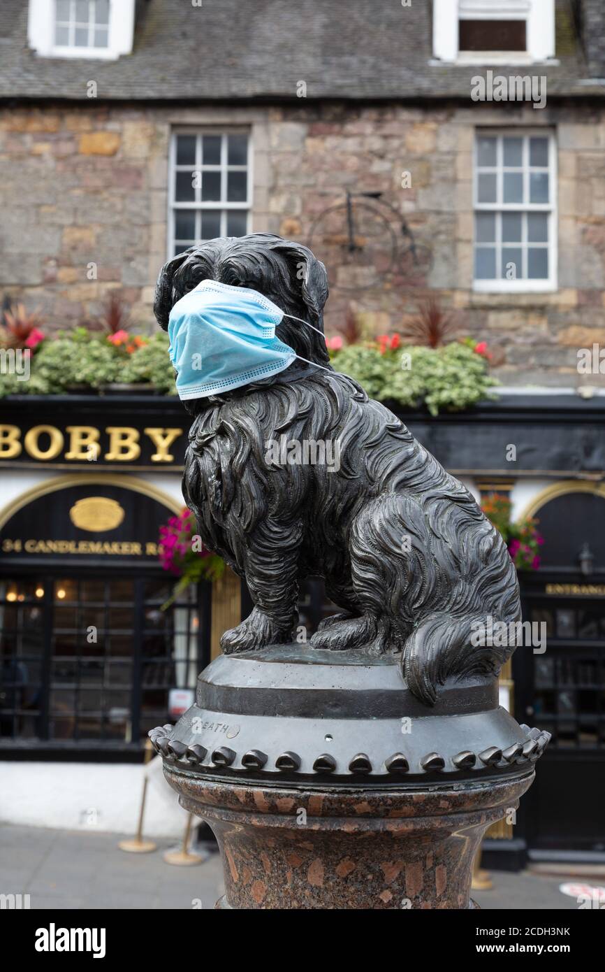 Covid 19 UK; The statue of Greyfriars Bobby with a facemask on during the Coronavirus pandemic, Edinburgh Scotland UK Stock Photo