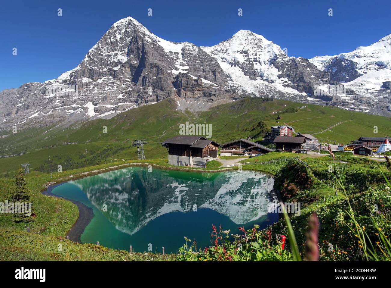 Landscape with Eiger, Moench and part of Jungfrau (to the right), in the Swiss Alps (Bernese Alps) reflecting in a pond at Kleine Scheidegg. Stock Photo