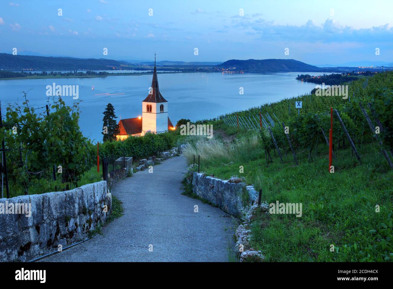 Evening landscape with a winding road and church in the vineyards above Ligerz, on Lake Biel (Lake Bienne) in Switzerland. Stock Photo