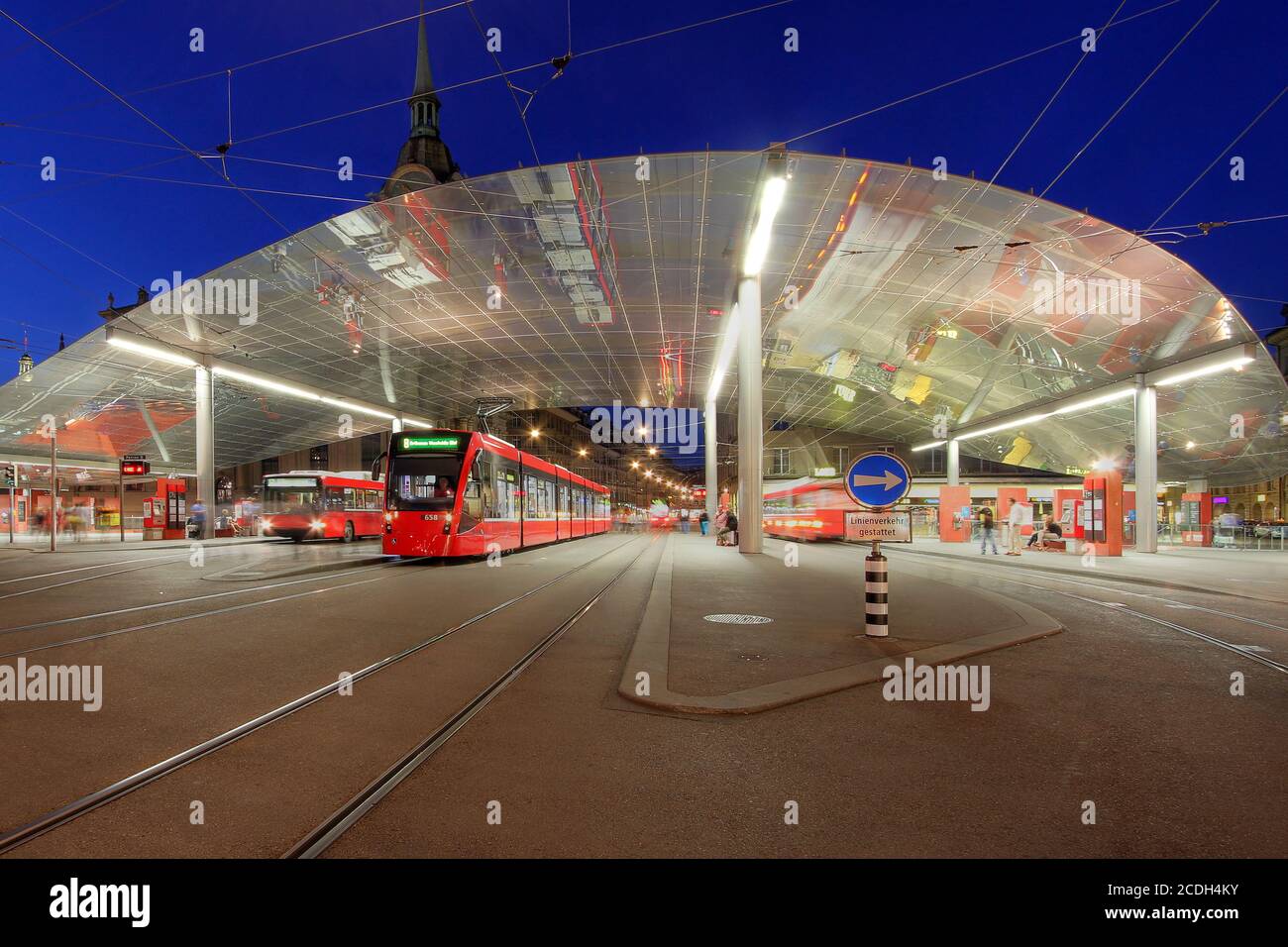 Covered tram station in Bahnhofplatz (the square in front of the main Train Station) in Bern, Switzerland at night. Stock Photo