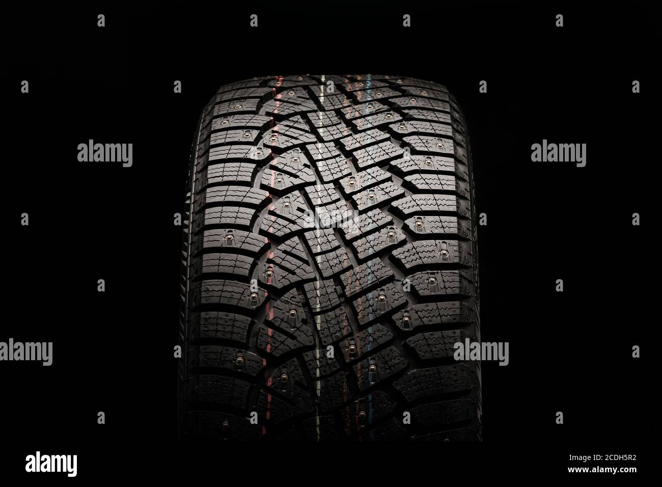winter studded tire, front view. close-up on a black background Stock Photo
