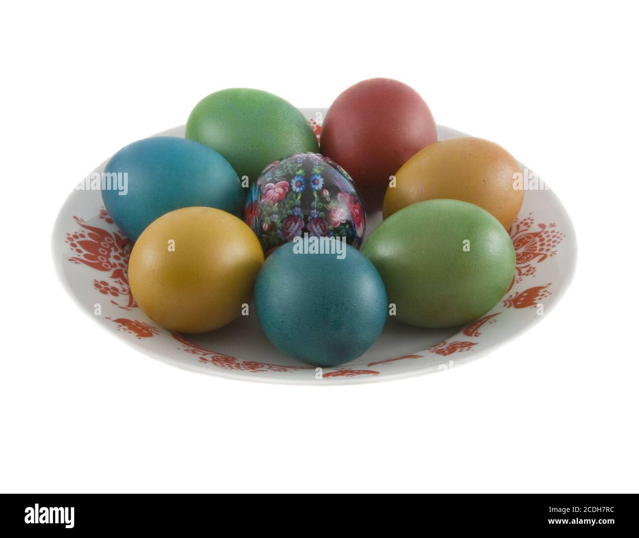 The easter decorated eggs lying in white porcelain plate with a red ornament Stock Photo