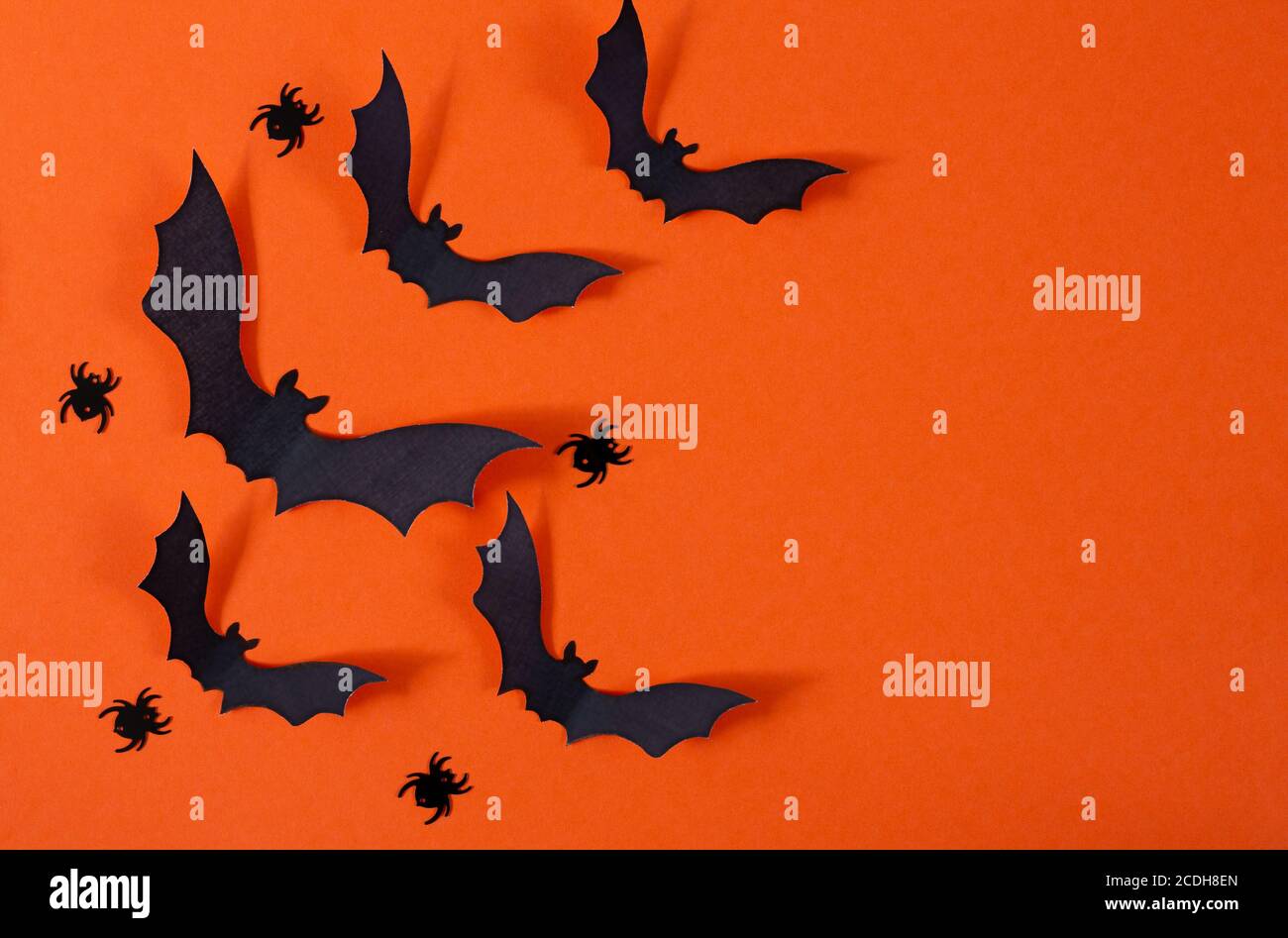Halloween decor with spiders and black paper bats flying over orange ...