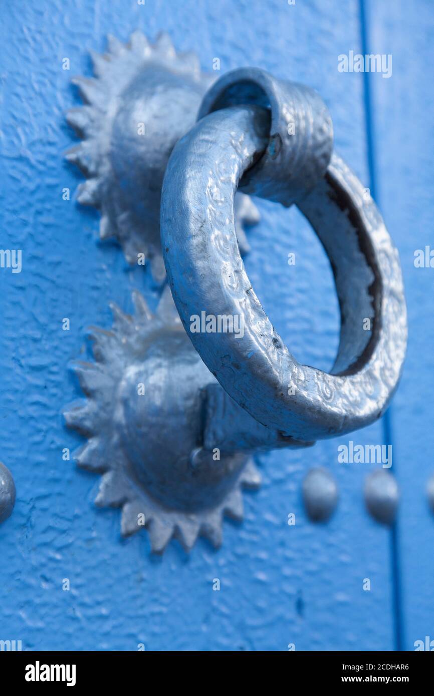 A door knocker on and old wooden door painted blue in Chefchaouen, Morocco Stock Photo