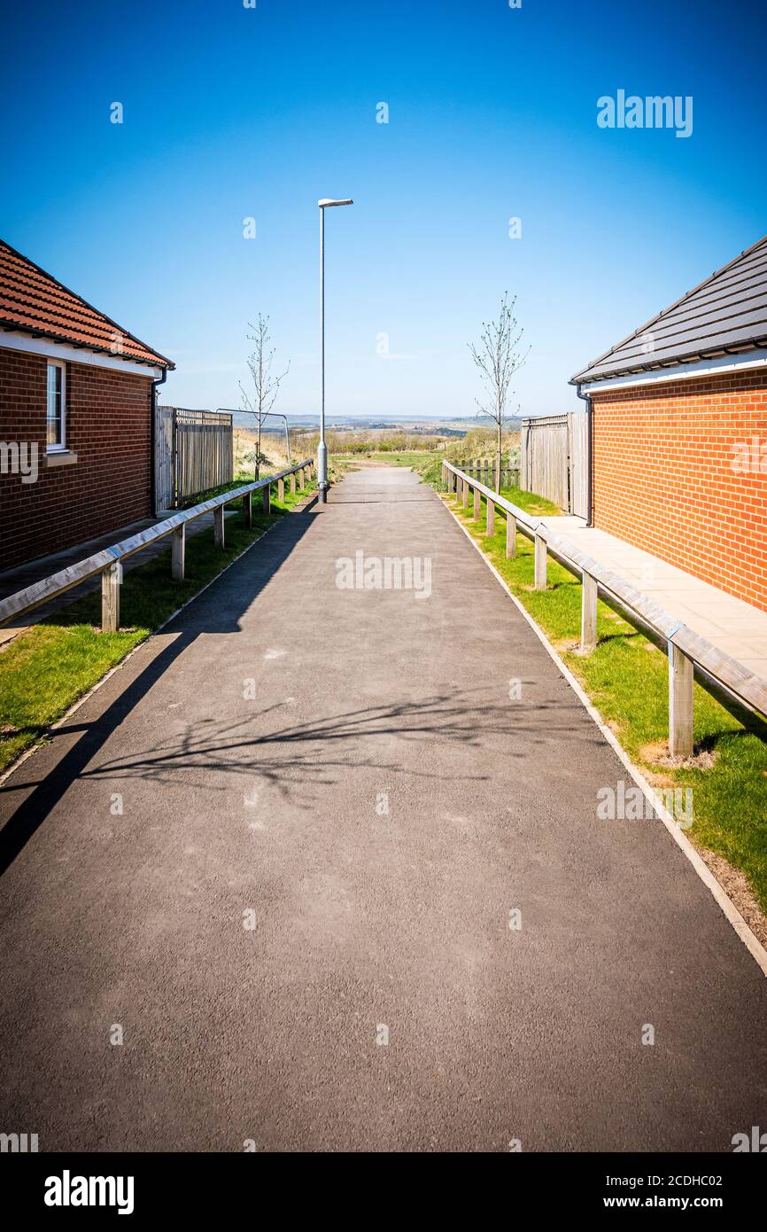A path between modern single storey houses in Consett, County Durham, UK Stock Photo