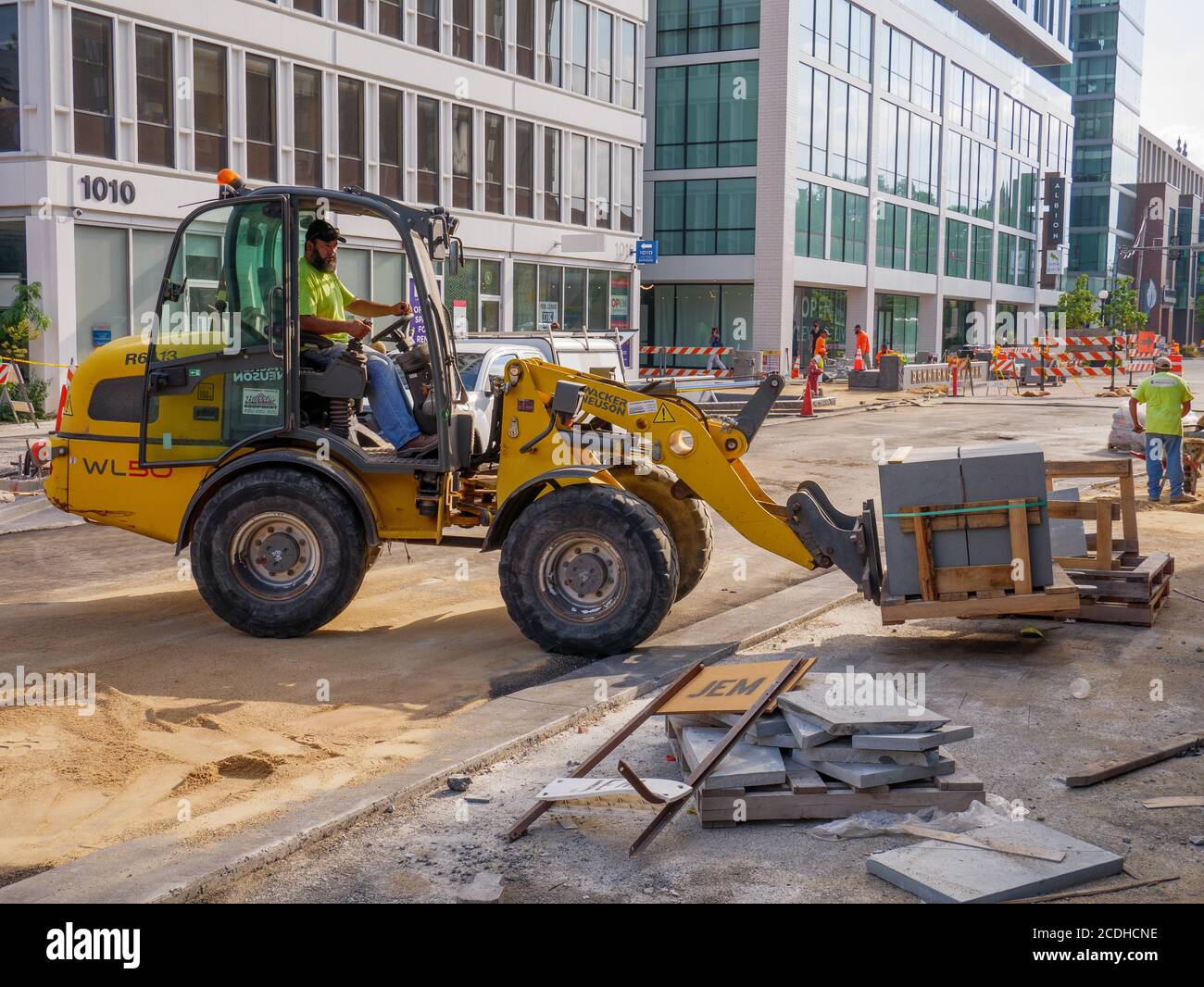 Loader with fork lift attachment lifting pavement blocks. Lake Street Reconstruction Project, Oak Park, Illinois. Stock Photo
