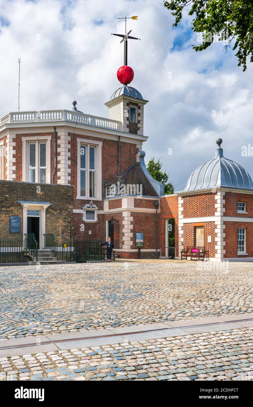 The Grenwich Prime Meridian line crosses the cobblestones in front of Flamsteed House at the Royal Observatory Greenwich. Beneath the weather vane is Stock Photo