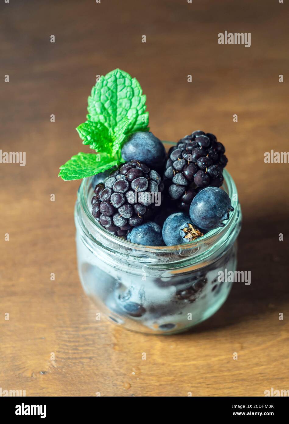 Frozen blackberry and blueberry berries, closeup. Selective focus, copy space. Stock Photo
