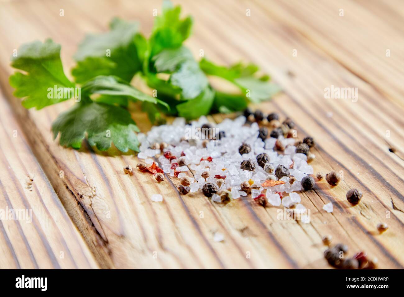 Green leaves of celery, salt and pepper on a wooden table Stock Photo