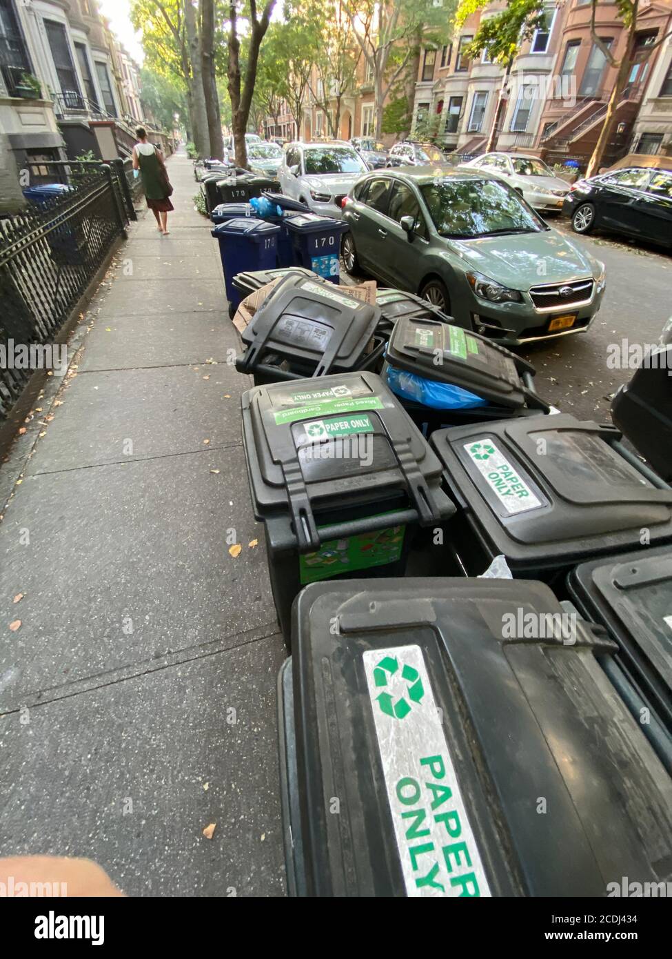 Garbage cans at the curb on garbage collection day in a residential neighborhood in Brooklyn, New York. Stock Photo