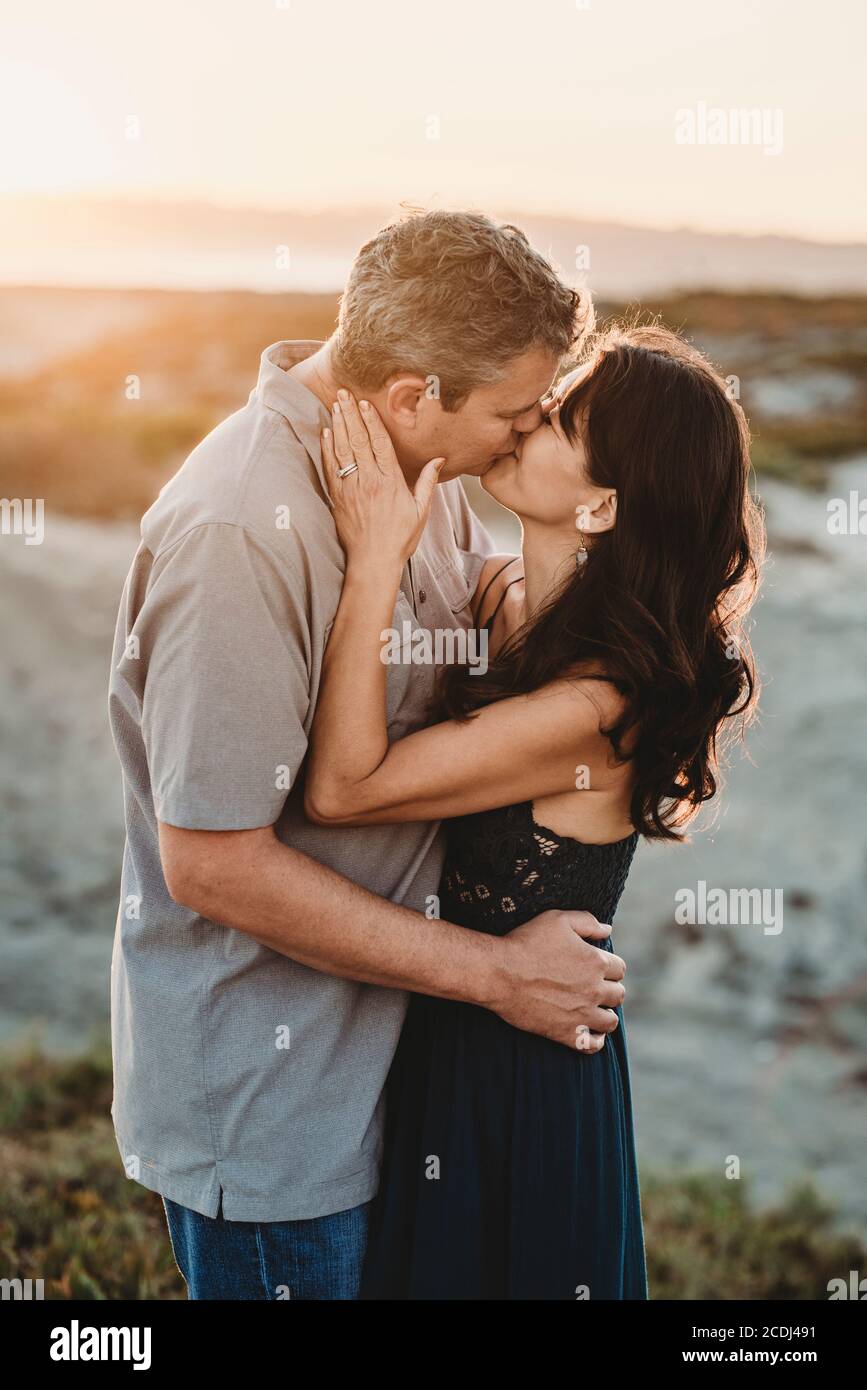 Husband and wife exchange romantic kiss at the Bach Stock Photo ...