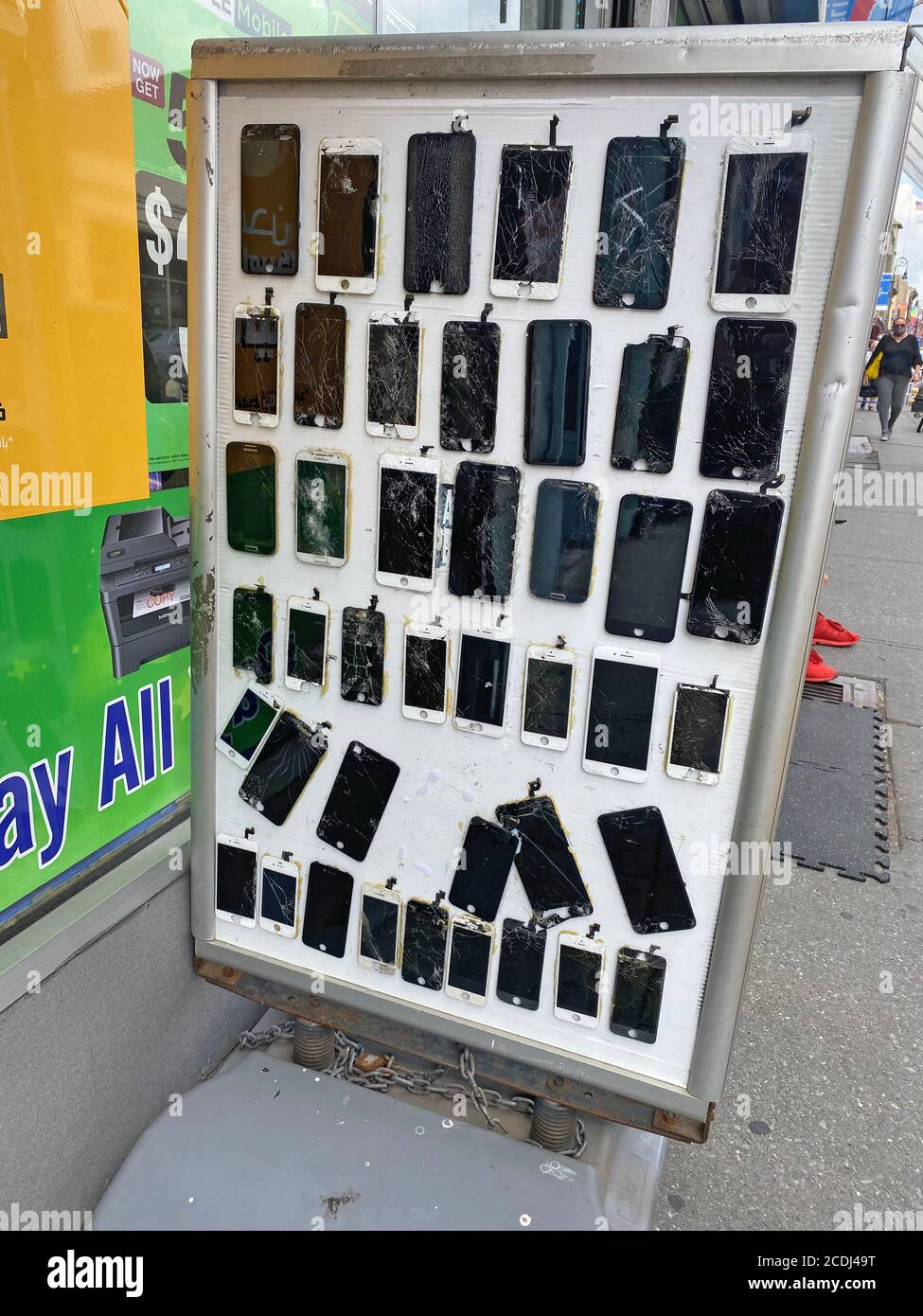 Display of cracked cell phone screens and other damage outside a store that fixes cell phones a lucrative small business on Manhattan Avenue in Brooklyn, New York. Stock Photo