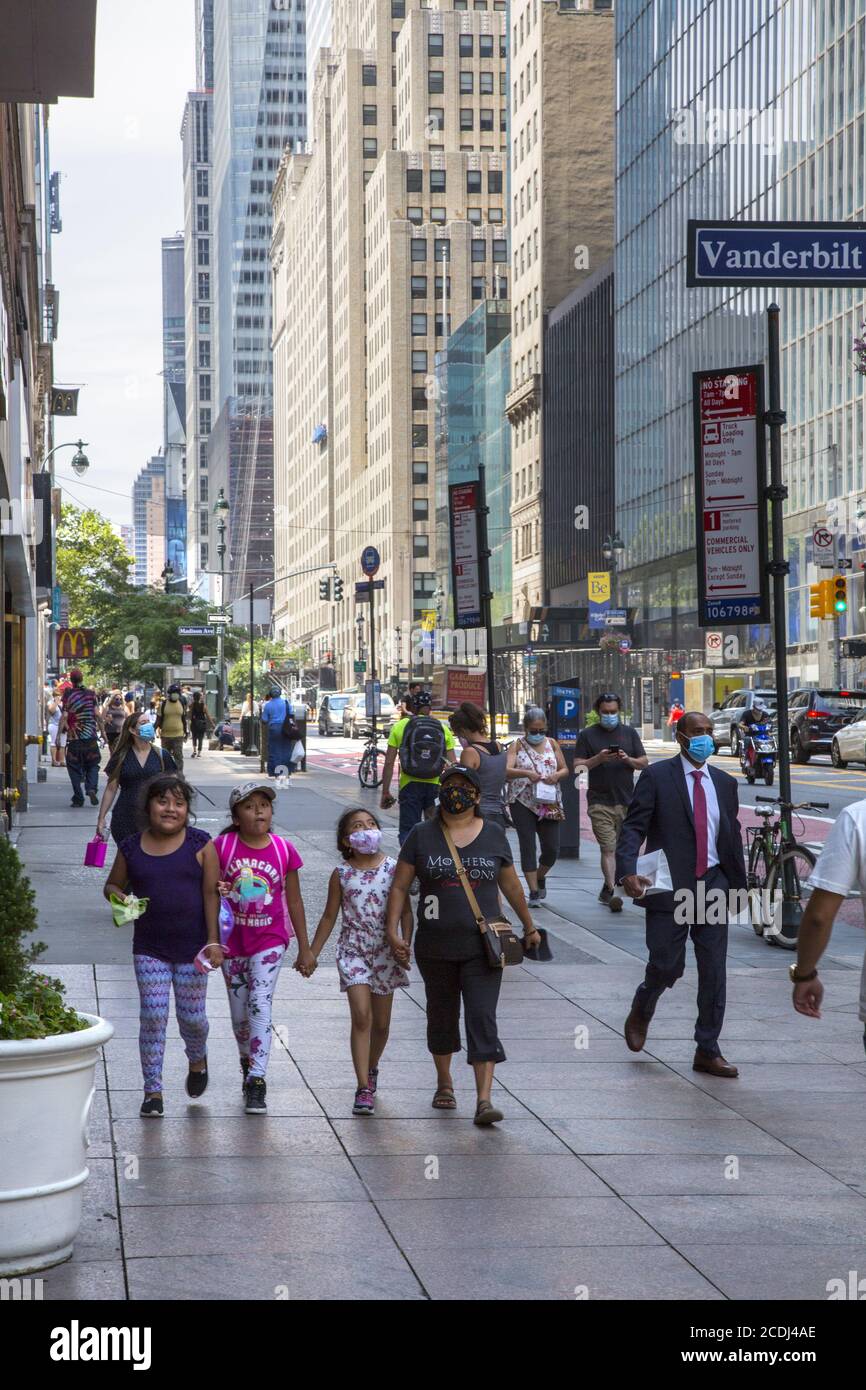 Hispanic mom and children walk east on 42nd at Vanderbilt Ave. by Grand Central Station in Manhattan, NY City. Stock Photo